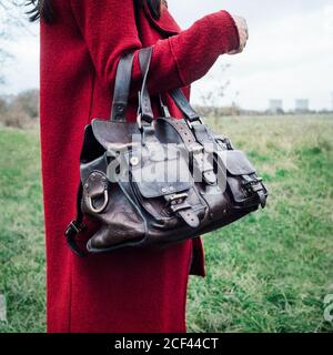 Woman in Red soprabito tenendo un Mulberry Roxanne borsette in cuoio Foto Stock