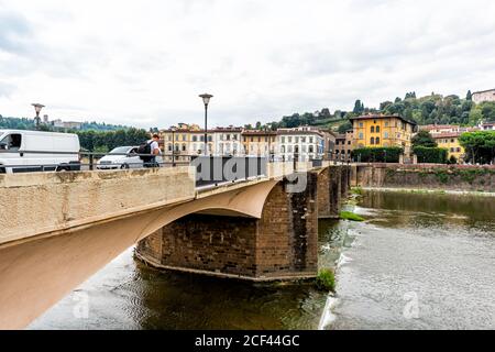 Firenze, Italia - 31 agosto 2018: Firenze edifici gialli arancio e fiume Arno durante la mattina nuvolosa estiva in Toscana con persone e auto si incrociano Foto Stock