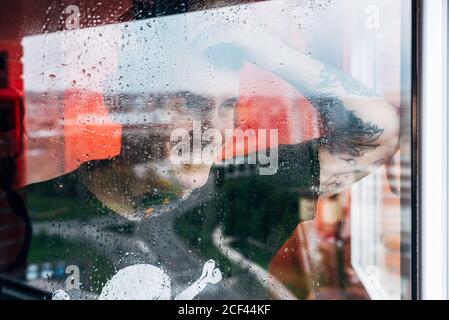 Uomo che guarda attraverso la finestra Foto Stock