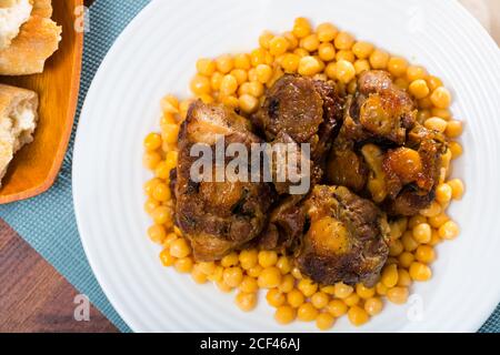 Brasati oxtails con ceci su una piastra bianca Foto Stock