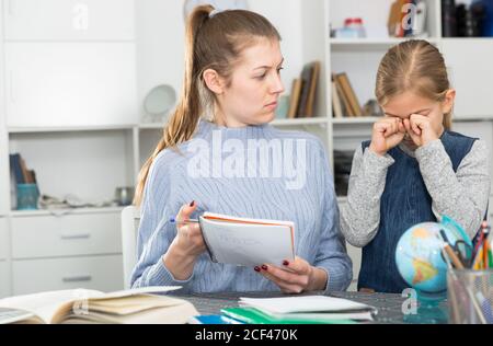 Donna che si lamenta della scarsa prestazione accademica di sua figlia Foto Stock