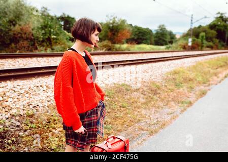 Donna in piedi alla stazione ferroviaria Foto Stock