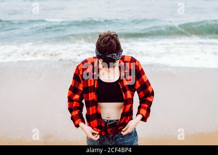 Donna in piedi su sabbia bagnata sulla spiaggia Foto Stock