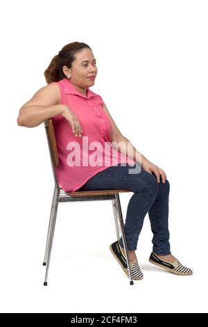 ritratto di una donna seduta su una sedia con il corpo in profilo e sguardo laterale su sfondo bianco, Foto Stock