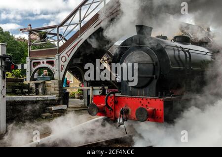 La locomotiva a vapore Repulse, ingolfata a vapore, esce dalla stazione di Haverthwaite su una linea ferroviaria di diramazione verso Lakeside nel Lake District (Regno Unito) Foto Stock