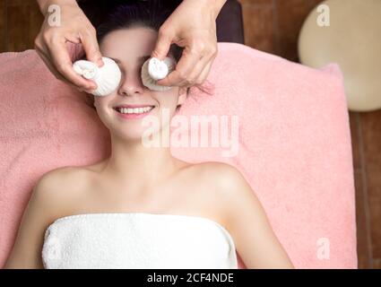 Massaggio viso tailandese con sacchetti d'uva nel salone termale Foto Stock