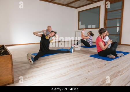 Mamme che si allenano con i bambini in palestra Foto Stock