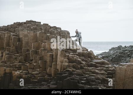 Donna in piedi sulla scogliera e contemplare Foto Stock