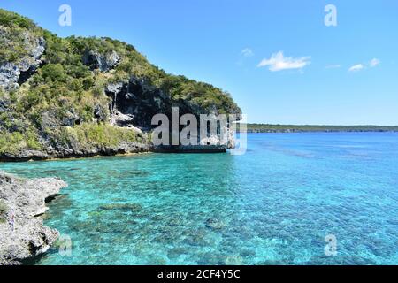 La scogliera rocciosa delle scogliere di Jokin sull'isola di Lifou, Nuova Caledonia nel Pacifico del Sud. Una barriera corallina può essere vista sotto l'oceano turchese. Foto Stock