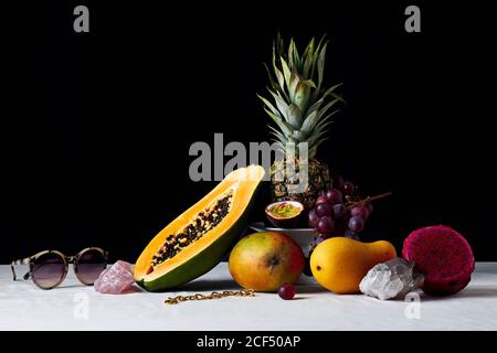 Ancora vita con frutti tropicali, gemme e oggetti vari Foto Stock