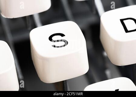 Un primo piano estremo o una macro di un keycap di plastica bianca da una macchina da scrivere manuale con profondità di campo bassa e messa a fuoco selettiva. Foto Stock