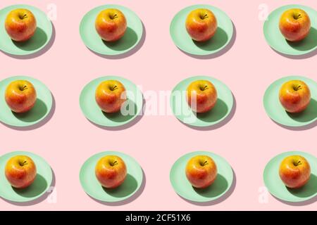 Mele fresche in piastra su sfondo ciano. Vivace motivo colorato Foto Stock