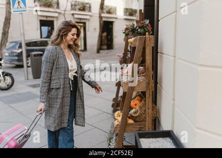 Sorridente turista femminile vicino al negozio di alimentari Foto Stock