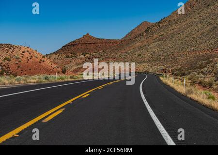 Vista laterale strada asfaltata nel soleggiato giorno d'estate. Autostrada, Arizona, Stati Uniti. Foto Stock