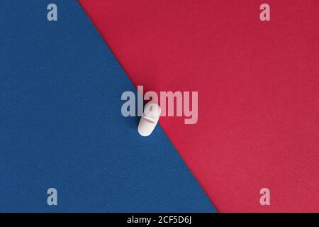 Vista dall'alto della pillola di prescrizione per il trattamento dell'influenza fogli di carta rossi e blu Foto Stock