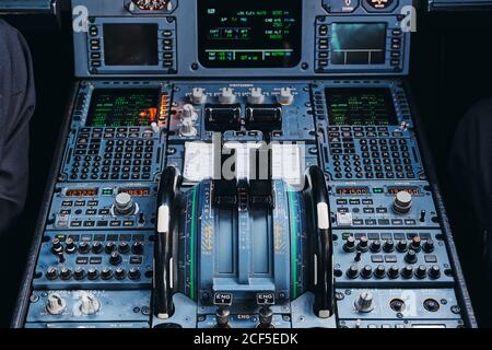 Dalla parte superiore delle leve di comando della potenza del motore e si accende quadro strumenti all'interno di un aereo civile contemporaneo Foto Stock