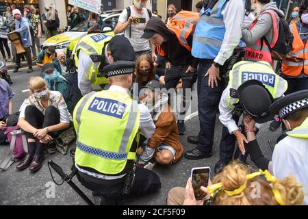 I poliziotti parlano con i manifestanti durante la dimostrazione.gli attivisti della ribellione animale parte dei manifestanti della ribellione estinzione bloccano Victoria Street con un camion della fattoria con 2 attivisti super incollati al tetto, mentre altri all'interno erano chiusi in catene. Foto Stock