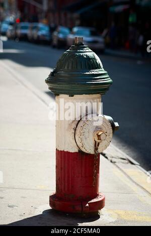 Idrante antincendio rosso e bianco vecchio stile situato sul marciapiede Sulla strada di New York City in giornata di sole Foto Stock