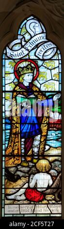 St. Edmund recita i Salmi, finestra di vetro colorato del 20 ° secolo, Chiesa di St. Edmund, Hunstanton, Norfolk. Scogliere a strisce di Hunstanton sullo sfondo Foto Stock