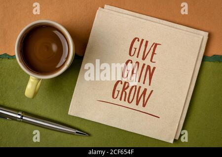 dare, guadagnare e crescere - concetto di sviluppo personale e aziendale - scrivere a mano su un tovagliolo con una tazza di caffè Foto Stock