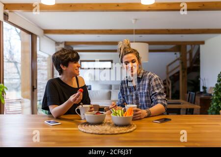 Due belle e giovani donne che fanno colazione a casa e. divertirsi Foto Stock