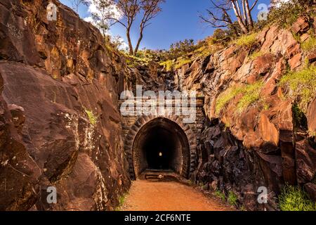 Vecchio tunnel del treno nascosto nel parco nazionale con formazione rocciosa valle Foto Stock