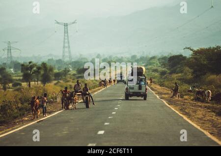 Afar, Etiopia - 05 novembre 2018: Paesaggio di auto a cavallo su strada con persone e animali a piedi in piena di sole, Etiopia Foto Stock