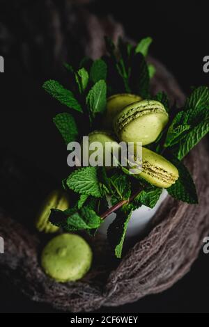 Verde macaron fatto in casa con menta su sfondo scuro. Cibo scuro. Foto Stock