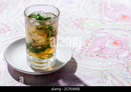 Bicchiere di tè freddo rinfrescante con cubetti di ghiaccio e limone fette poste sul tavolo nel caffè Foto Stock