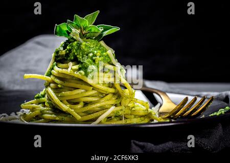 Gustosa pasta con salsa al pesto e parmigiano tavolo in ristorante di lusso Foto Stock