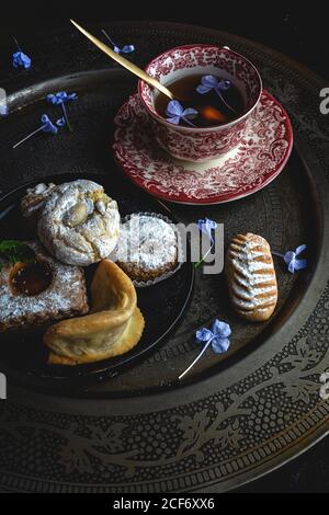 Tè tradizionale con menta e dolci arabi homedade assortiti su sfondo scuro. Ramadan. Islamico. Halal Foto Stock