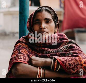 Città di Allahabad, India - FEBBRAIO, 2018: Primo piano ritratto di donna indù che indossa costume tradizionale seduto in strada durante il Prayag Kumbh Mela Festival Foto Stock