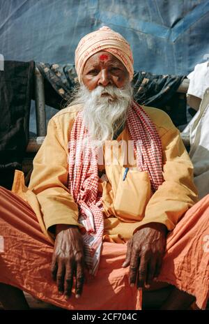 Allahabad, India - FEBBRAIO, 2018: Primo piano ritratto di un anziano indiano che indossa abiti tradizionali seduti sul pavimento Foto Stock