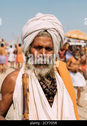 Allahabad, India - FEBBRAIO, 2018: Primo piano ritratto di un anziano indiano che indossa abiti tradizionali contro sfondo sfocato Foto Stock