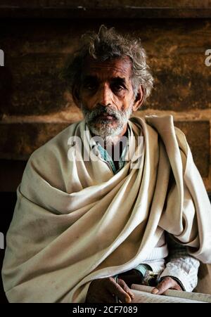 Varanasi, India - FEBBRAIO, 2018: Primo piano ritratto di anziano indiano indossare abiti tradizionali contro sfondo sfocato Foto Stock