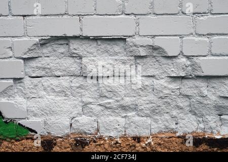 Difetto della parete in mattoni verniciato con vernice bianca Foto Stock