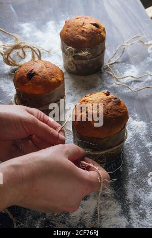 Persona che decora panettone con spago Foto Stock