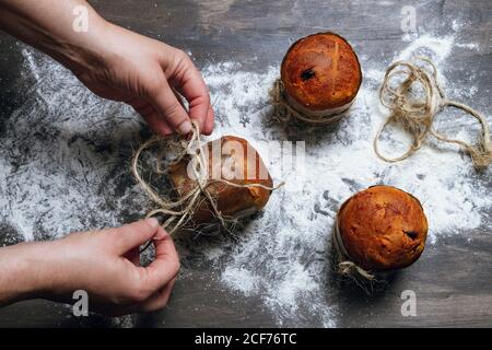 Persona che decora panettone con spago Foto Stock