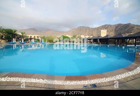 Dubai, Emirati Arabi Uniti - 31 luglio 2020: Cortile del Miramar Hotel con una grande piscina e colline sullo sfondo. Il marchio è stato fondato nel 1957 Foto Stock