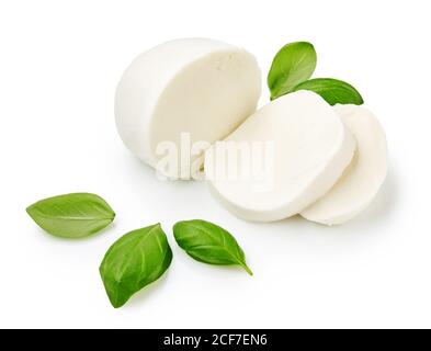 Pezzi di mozzarella di bufala con foglie di basilico. Formaggio a fette isolato su sfondo bianco. Foto Stock