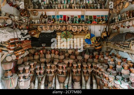 Gambia, Africa - 5 agosto 2019: Belle decorazioni locali in vendita con strumenti musicali e simboli ornamentali sul bancone della strada nel bazar Foto Stock