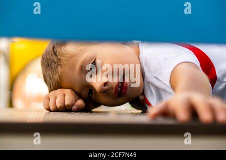 POZNAN, POLONIA - 30 agosto 2020: Giovane ragazzo caucasico polacco che posa su un equipaggiamento in un parco giochi Foto Stock