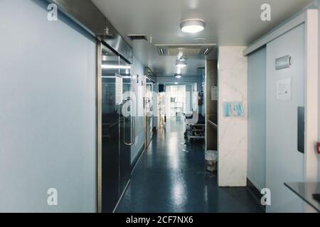 Corridoio desertato in clinica con carrello e luci dell'ospedale vuoti acceso Foto Stock
