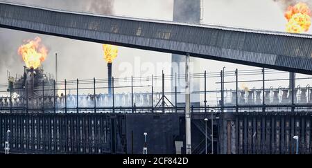 Edifici industriali e tubi resistenti alle intemperie che emettono fumo e fiamme a. fabbrica di coking Foto Stock