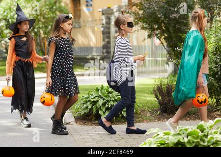 Gruppo di bambini in costumi di Halloween andare all'aperto per le delizie Celebrano Halloween Foto Stock