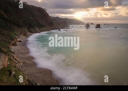 Dall'alto scenico e tranquillo mare con calme onde azzurre Luce di sole che tramonta sulla spiaggia rocciosa di Silence o Gaviero Foto Stock