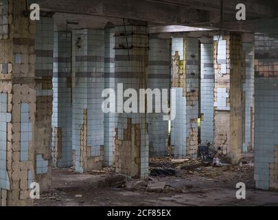 Muri in cemento e resti di scale in vecchio abbandonato industriale edificio con terreno disordinato Foto Stock