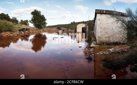 Edifici abbandonati allagati da acqua rossa a la Naya un villaggio minerario a Riotinto, Huelva Foto Stock