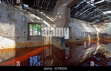 Edifici abbandonati allagati da acqua rossa a la Naya un villaggio minerario a Riotinto, Huelva Foto Stock