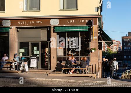 Ristorante Oiva crogiolarsi al sole serale all'angolo di Porthaninkatu e Kolma linja nel quartiere di Kallio a Helsinki, Finlandia Foto Stock